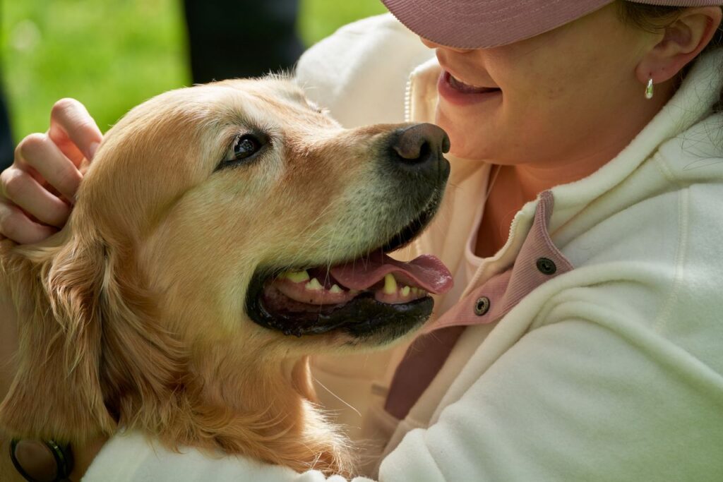 Heartwarming moment of a girl hugging her Golden Retriever outdoors, radiating joy and affection.