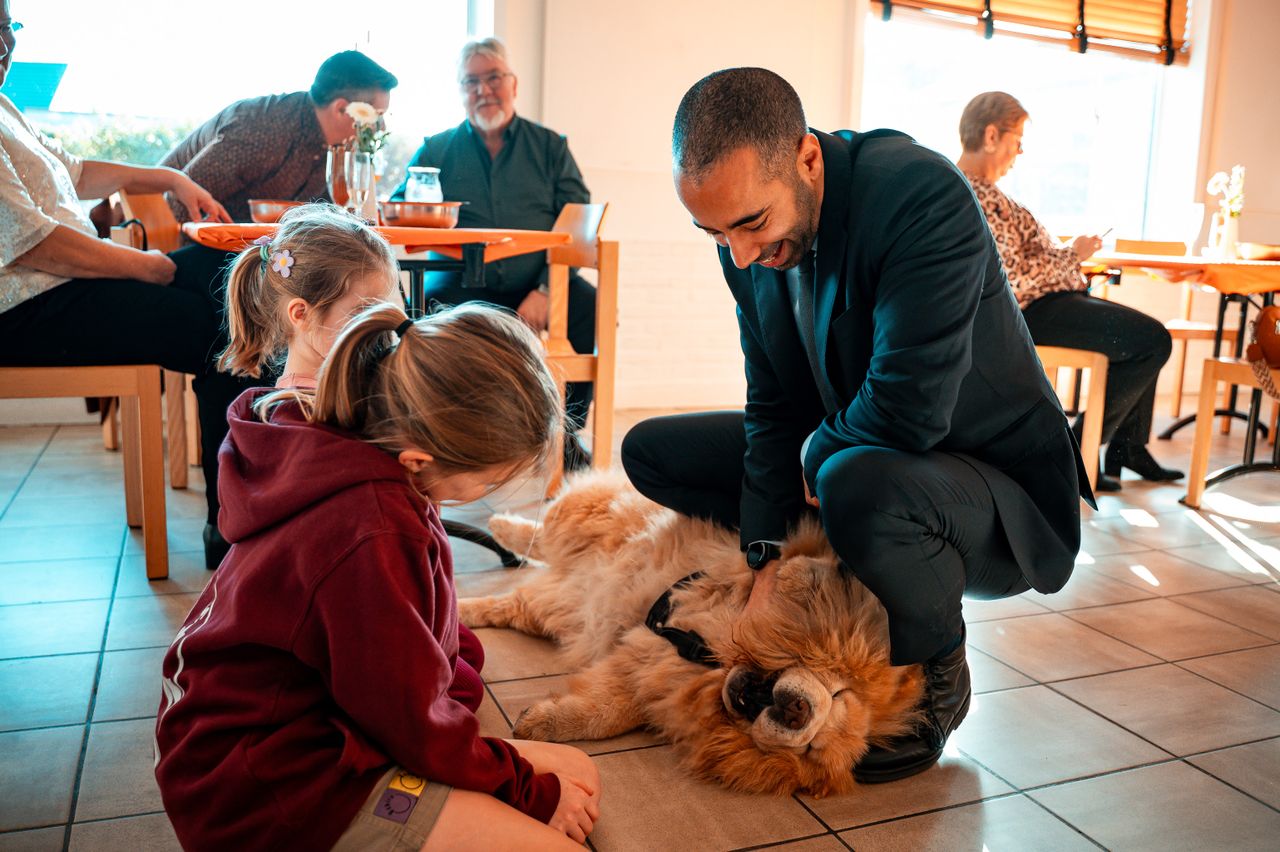 A heartwarming family scene with children and a dog in a cozy indoor setting.